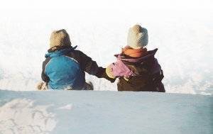 Winter Warmth Drive image of two kids sledding down a hill